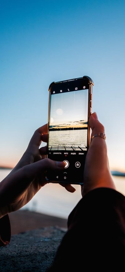 兼职 App 岗位列表页截图：手机屏幕上纵向排列着带缩略图的兼职卡片，每张卡片右下角有绿色日结标签与距离公里数，背景为浅粉色调